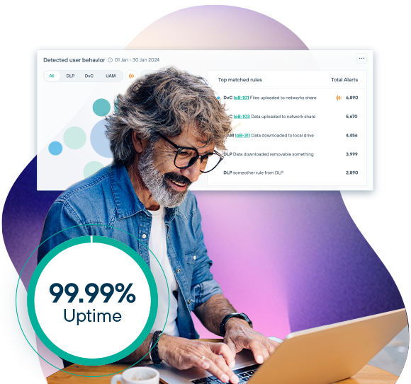 A grey-haired, bespectacled man looks happy as he works on a laptop.