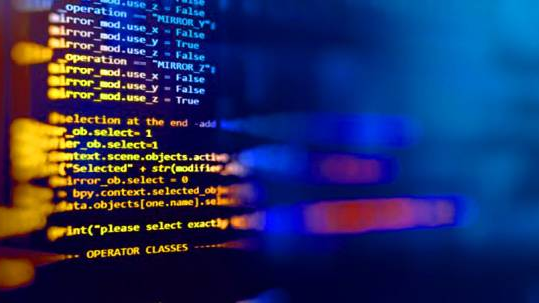 Partially obscured computer code on a screen, lit up in orange and blue