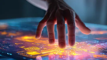 The fingertips of a hand rest on a bright digital surface